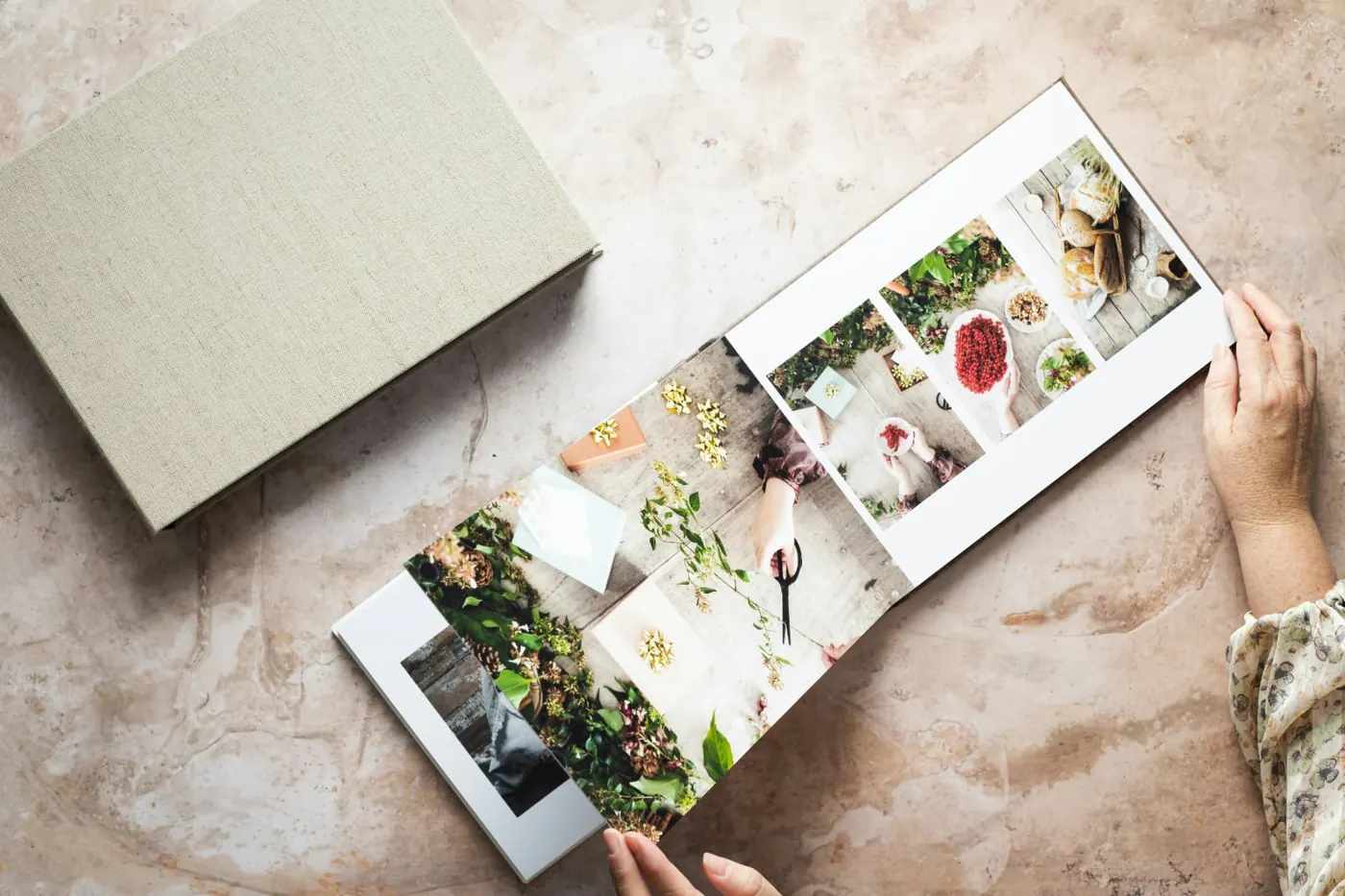 A linen-bound memorial photo book lying open on a stone surface